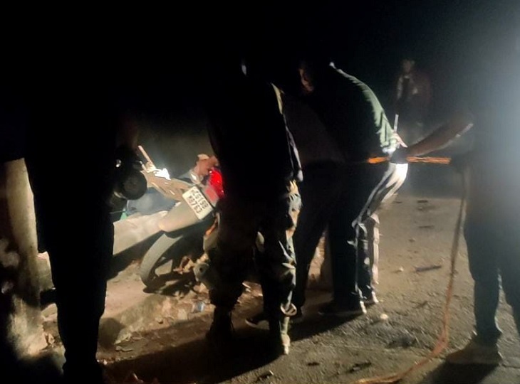 बाइक को नदी से बाहर निकालते जवान।