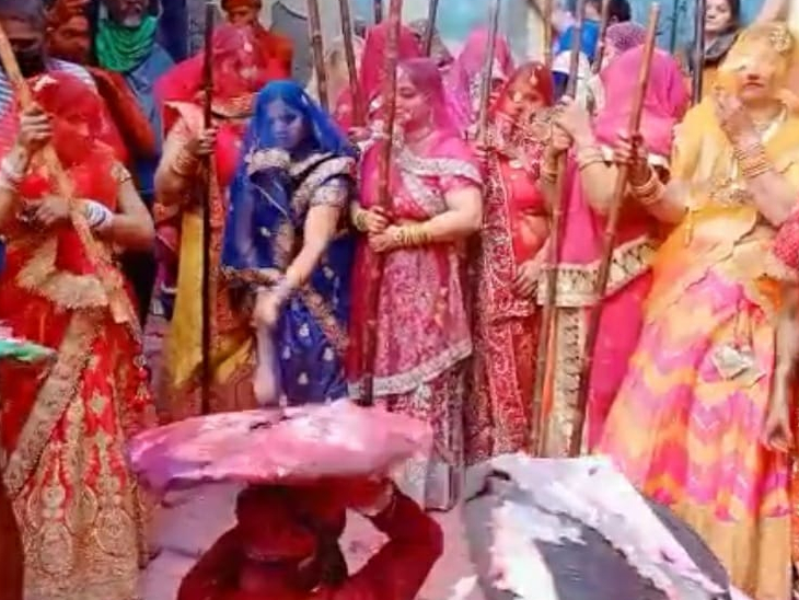 नंदगांव के हुरियारे बरसाने की गोपियों के लट्ठ से बचते हुए।