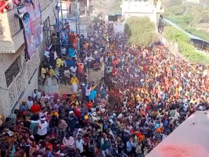राधाजी के मंदिर पर सैकड़ों की संख्या में इकट्‌ठे हुए लोग हवा में रंग गुलाल उड़ाते ।