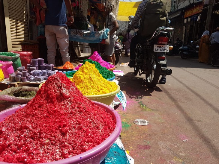 होली के बाजार में इस बार फिल्म पुष्पा वाली टीशर्ट : लिखा है-मैं झुकेगा नहीं मगर होली खेलेगा; शराब दुकानों में उमड़ी भीड़ रंग गुलाल से गोल बाजार की रंगीन गली।