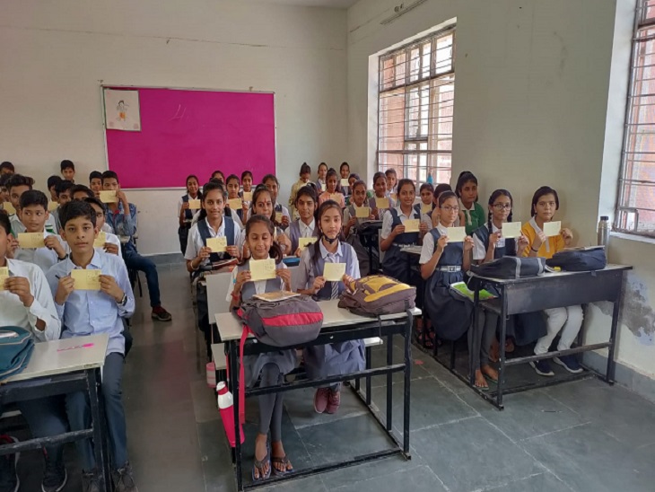 पोस्टकार्ड लिखते हुए स्टूडेंट। - Dainik Bhaskar