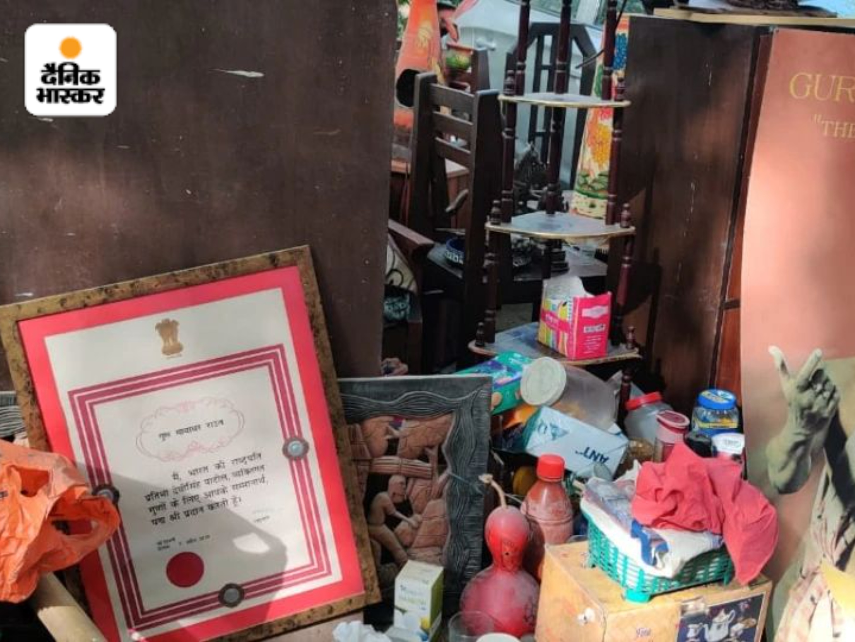 सड़क पर सामान के साथ पड़ा हुआ मायाधर राउत का पद्मश्री सर्टिफिकेट।