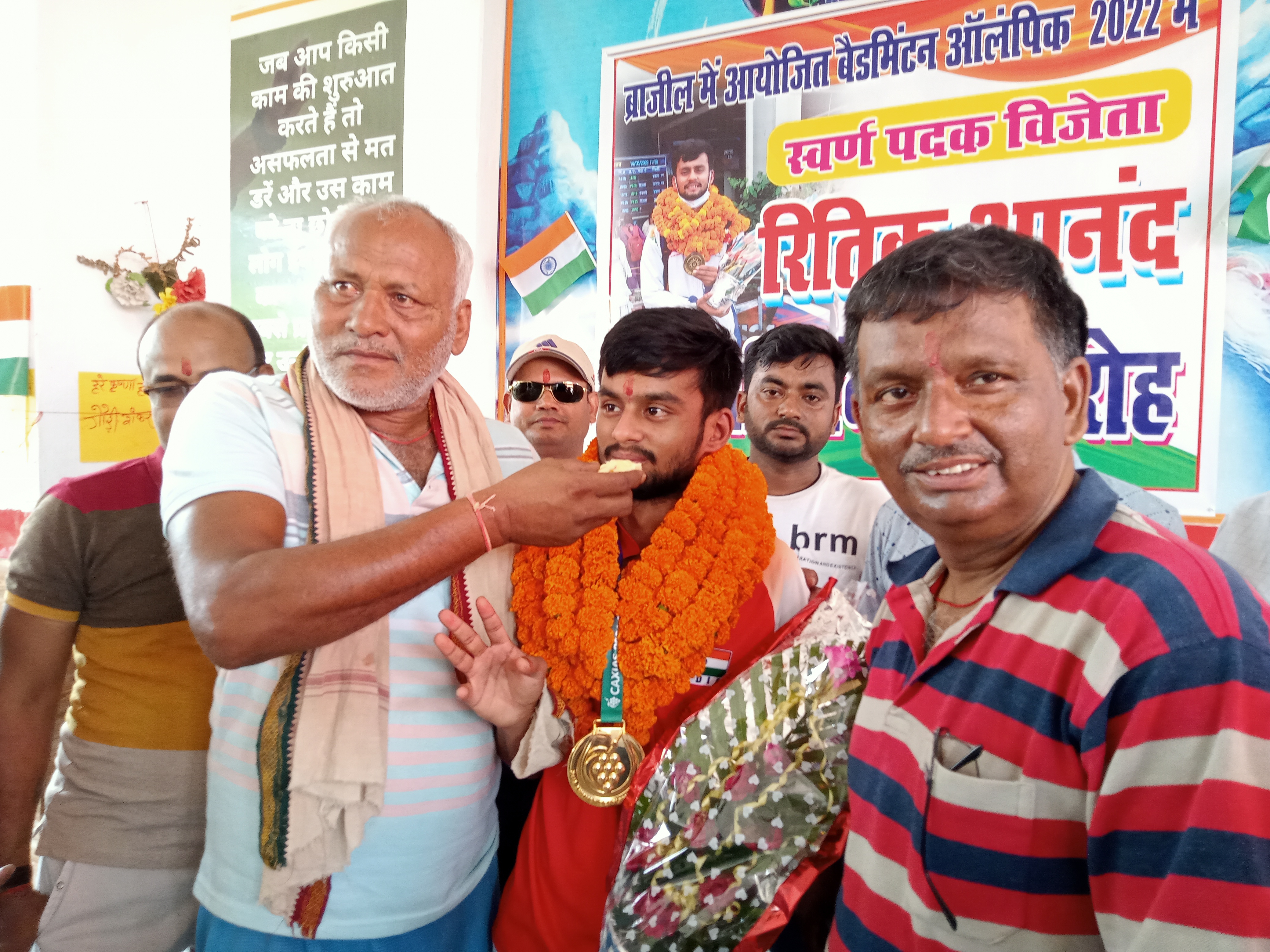 मिठाई खिलाते ग्रामीण।