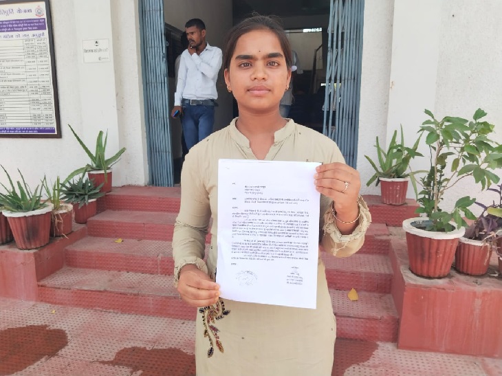 शिकायत के आवेदन की कॉपी दिखाती छात्रा।