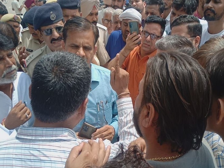 रोड जाम करके खड़े लोगों को समझाते अधिकारी।