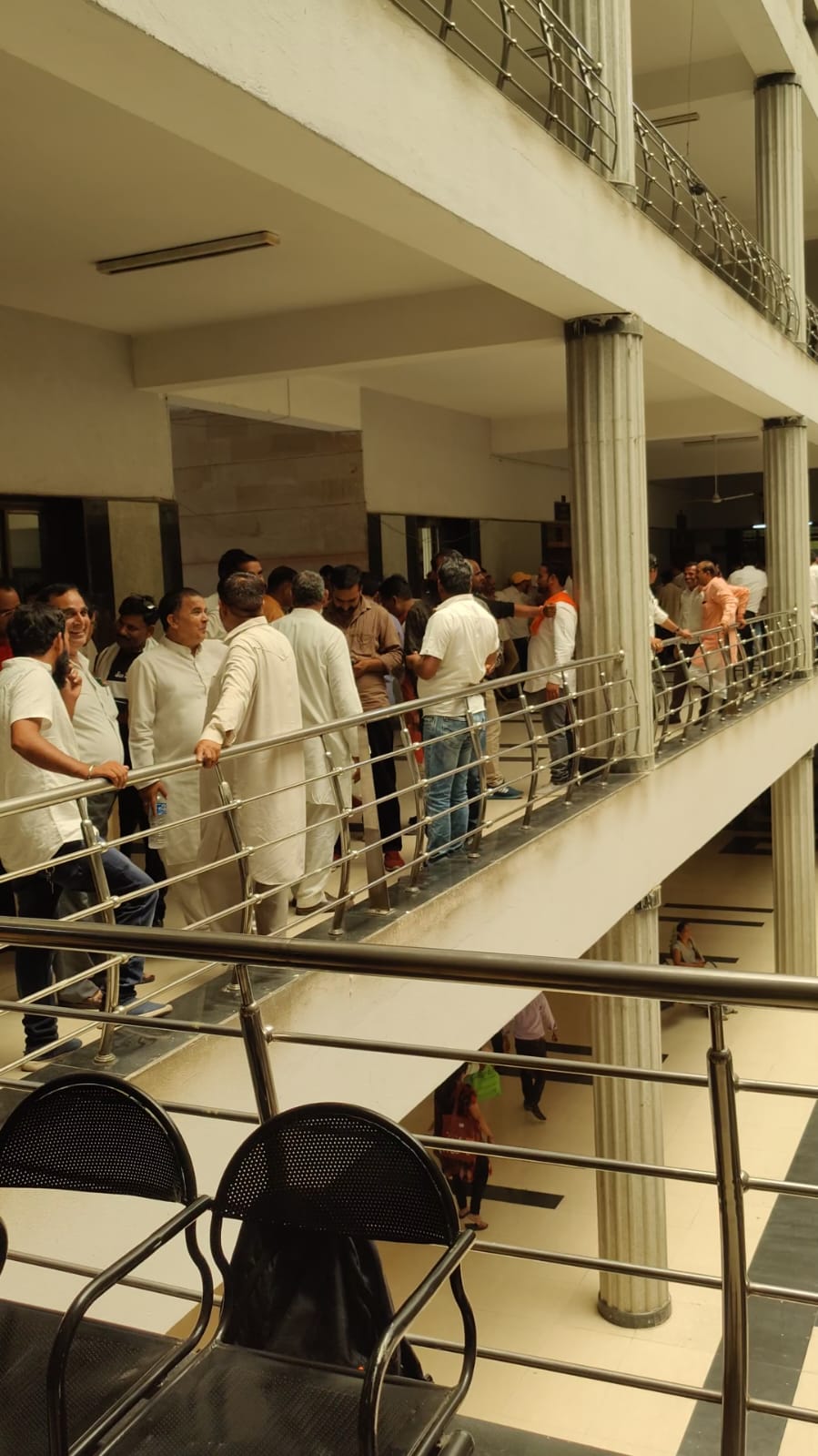 कॉरिडोर में इंतजार करते समर्थक।
