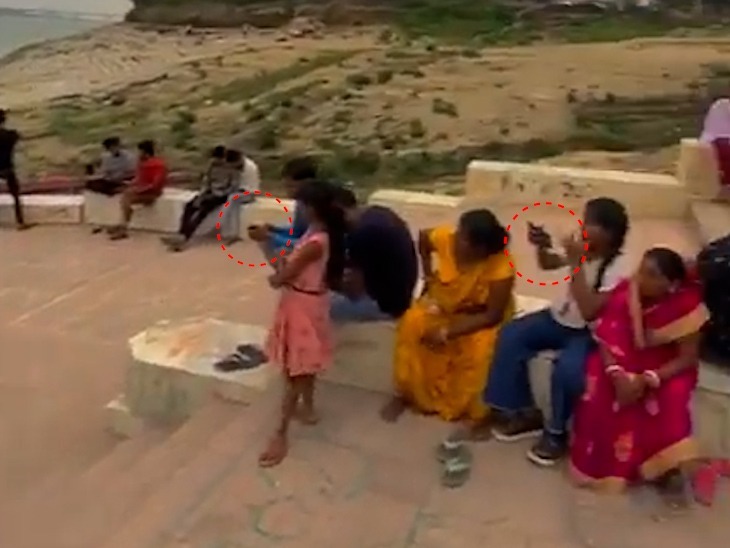 सैकड़ों की संख्या में युवा और बच्चे जिले के नाथ बाबा घाट पर बैठे हैं।