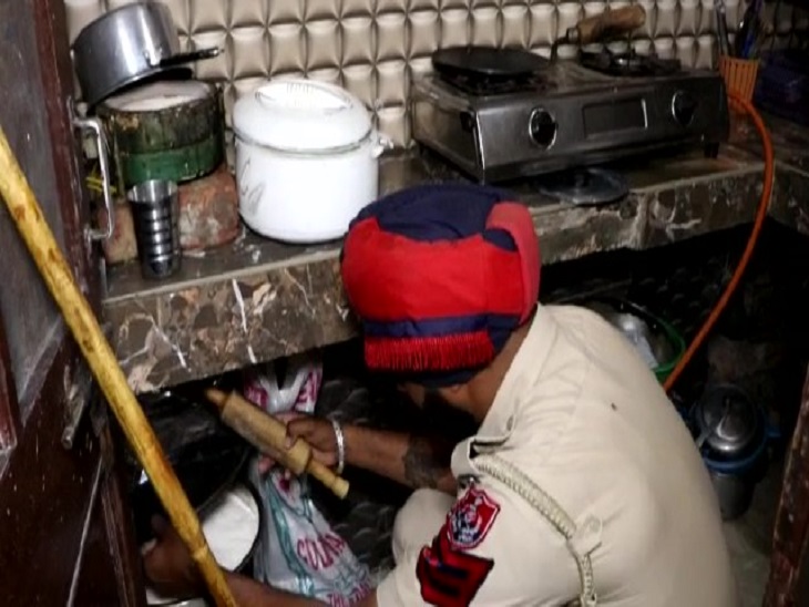 एक घर की रसोई में तलाशी लेता जवान