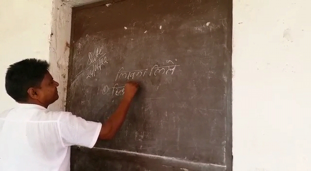 भागलपुर के सन्हौला प्रखंड के मध्य विद्यालय शाहूपाड़ा में ब्लैक बोर्ड नहीं रहने के कारण दरवाजा पर लिख पढ़ाते शिक्षक।