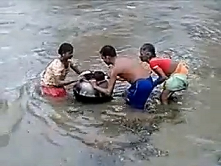 सुकमा में बच्चे को बर्तन में बिठाकर उफनाया बरसाती नाला पार करते ग्रामीण।