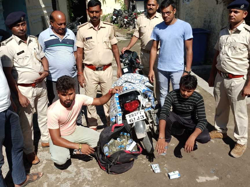 जब्त शराब के साथ दो युवक।