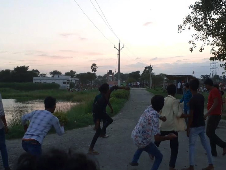 पत्थर फेंकते युवक।