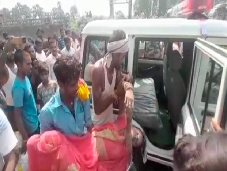 महिला को पुलिस गाड़ी में रखते लोग। - Dainik Bhaskar