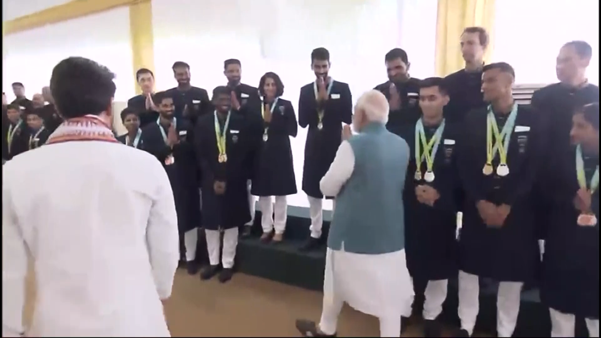 मेडल विजेताओं से मिले हुए प्रधानमंत्री नरेंद्र मोदी।