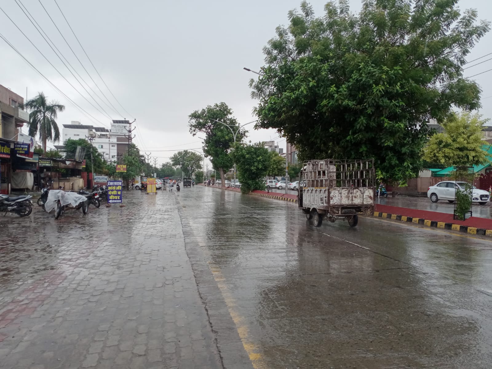 सड़कें भीगीं, लोगों ने सड़क किनारे ठहरकर किया बरसात से बचाव, गर्मी से