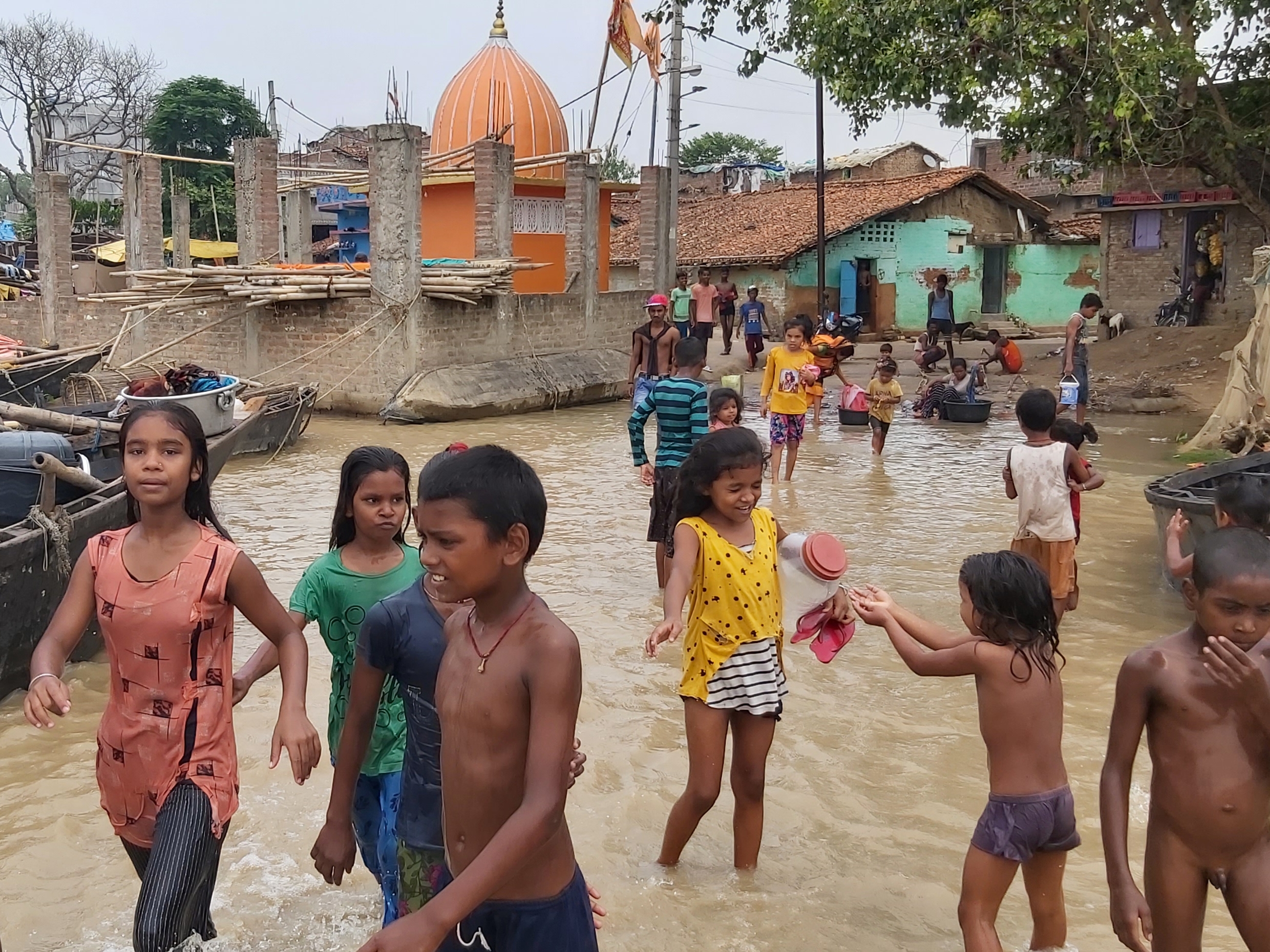 पानी में खेल रहे बच्चे।