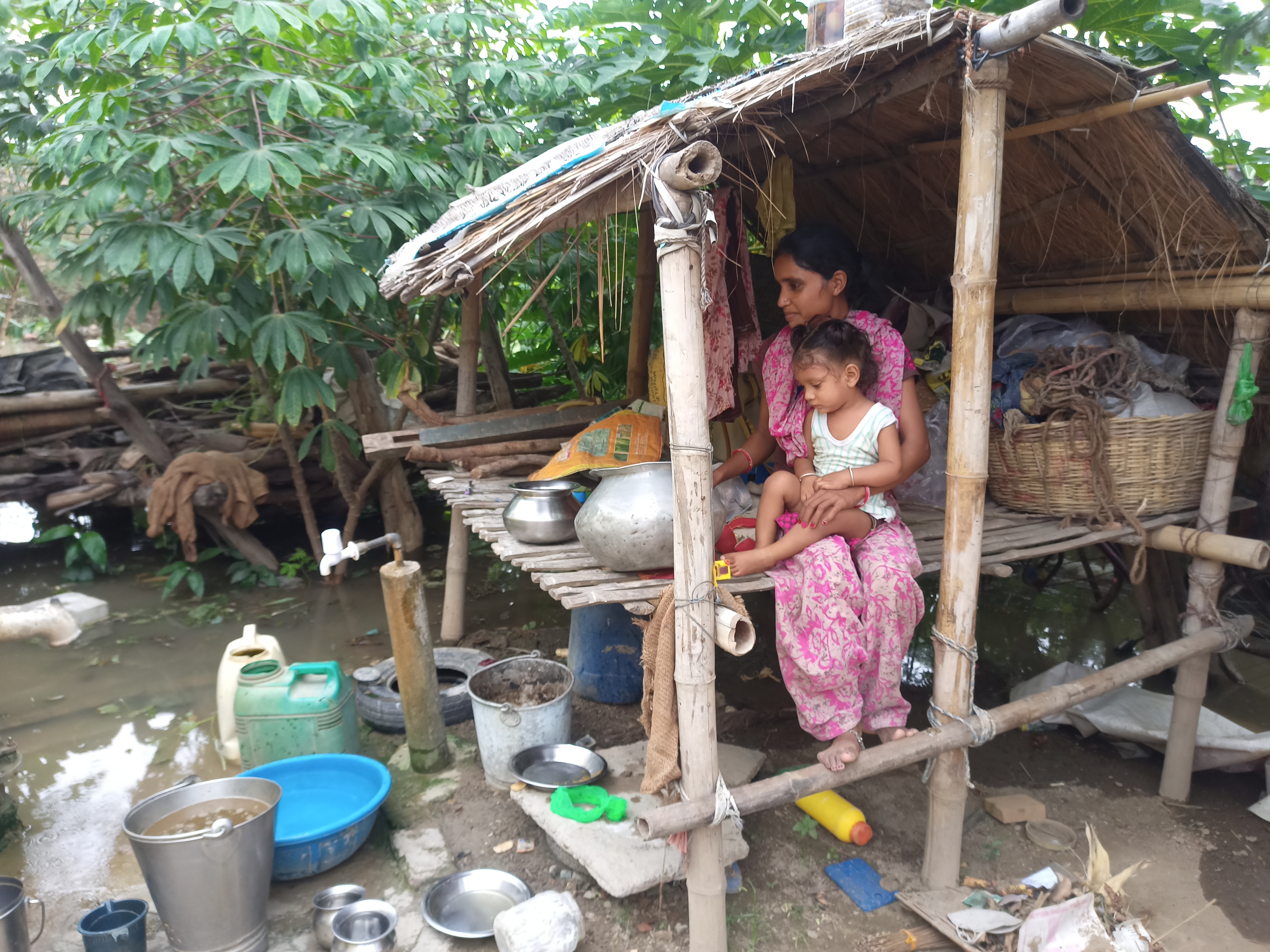 मचान पर बच्चे को लेकर बैठी महिला।