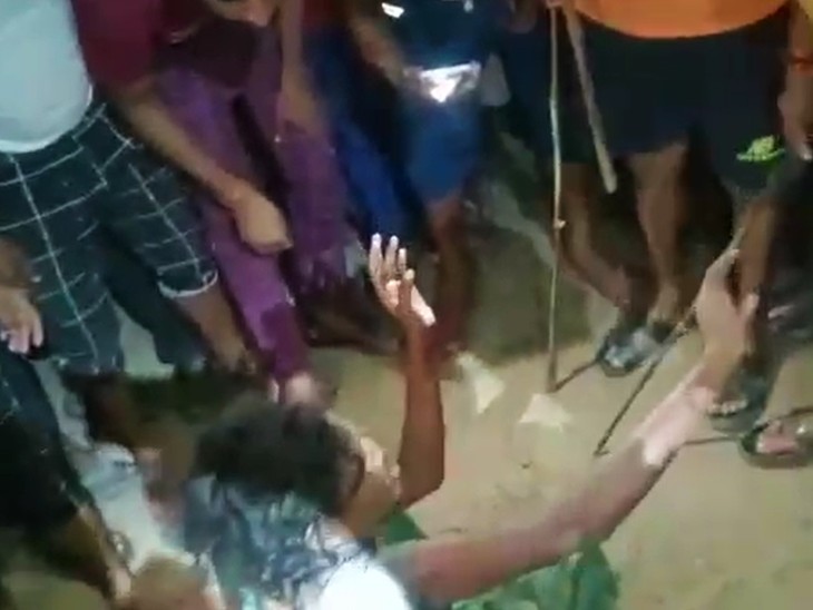 घेरकर लाठी-डंडे से महिला की पिटाई करते लोग।