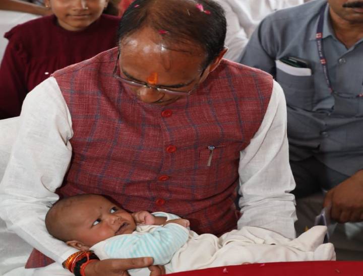 बच्चे को गोद में लेकर दुलारते सीएम शिवराज।