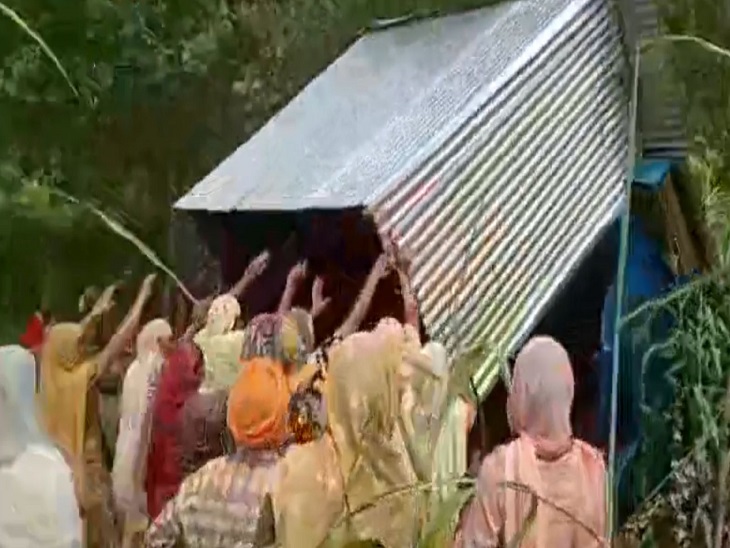 शराब ठेके के खोखे को गड्ढे में फेंकती महिलाएं।