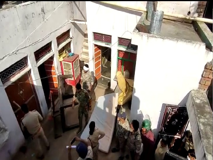 आरोपियों के घर का सामान बाहर निकलती पुलिस