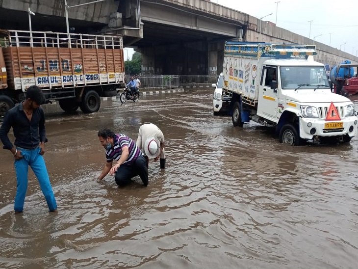 बाटा चौक पर गड्ढे में गिरे मोबाइल की तलाश करता बाइक सवार