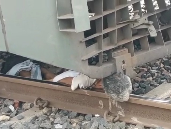 ट्रेन के नीचे फंसा बुजुर्ग का शव।