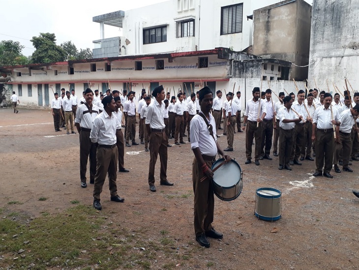 लाठी लेकर बैंड की धुन पर कदमताल करते सड़कों पर निकले स्वयं सेवक। - Dainik Bhaskar