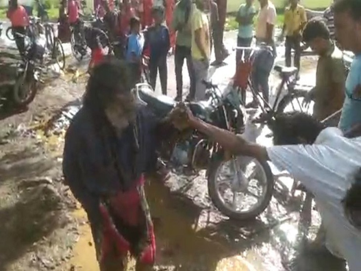 शख्स को मारने के लिए पकड़ते लोग।