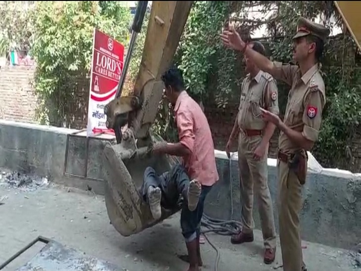 बुलडोजर से शव निकालने के बाद फोटो खीचने वाली पुलिस।