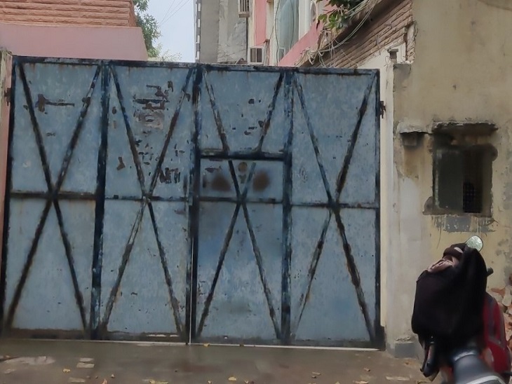 The company's closed gate, two watchmen sitting in a nearby room.