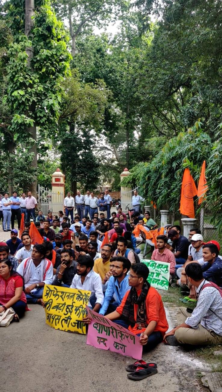 BHU के डीन ऑफ स्टूडेंट ऑफिस के बाहर फीस वृद्धि के खिलाफ अनिश्चितकालीन धरने पर बैठे छात्र।