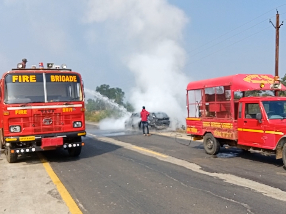 कार को आग लगाने की सूचना मिलने पर मौके पर पहुंचे दमकल कर्मचारी।