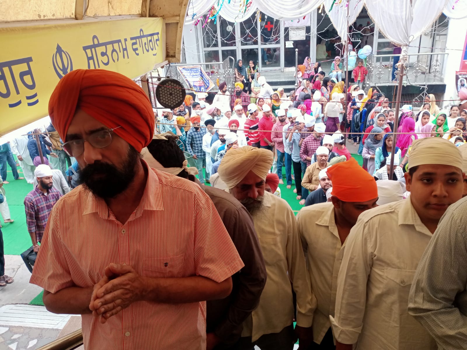 गुरुद्वारे में दर्शन के लिए इंतजार करते लोग।