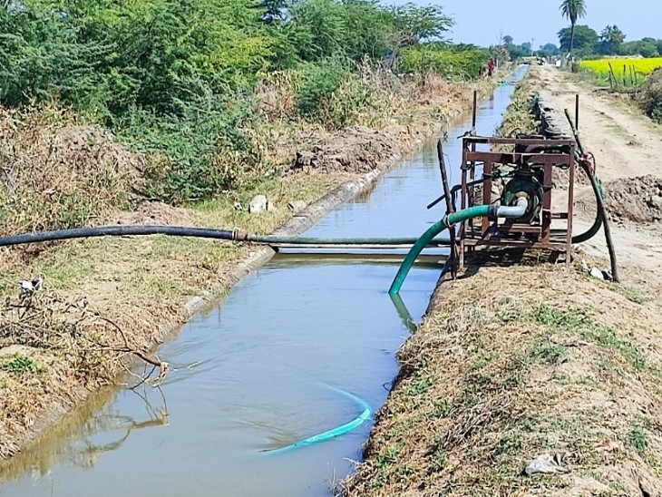 नहर के पास इंजन लगाकर किसान खेतों में पानी दे रहे हैं।