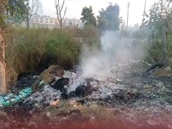 नहर के किनारे पड़े मिठाई के डिब्बों में आग सुलगती नजर आ रही है।