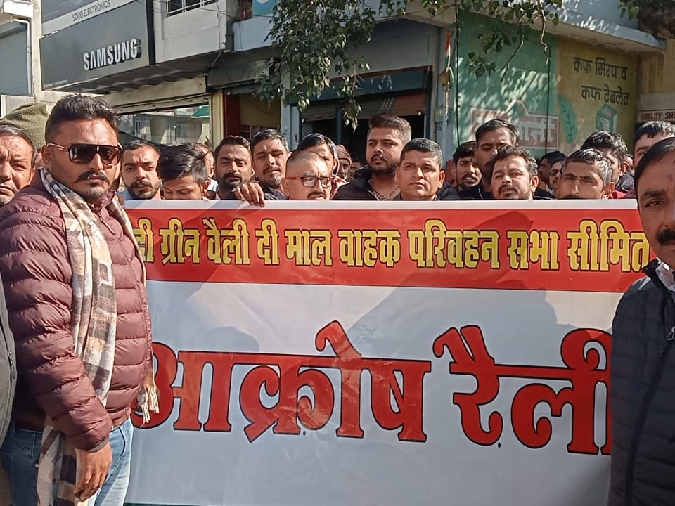 ट्रांसपोर्ट यूनियन के लोग बैनर लेकर प्रदर्शन करते हैं।