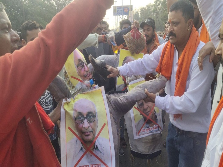 पुतले को जूते मारेते हुए