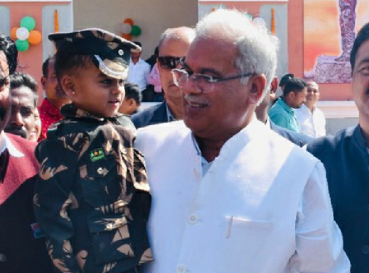 वर्दी पहने बच्चे को गोद में उठाए CM
