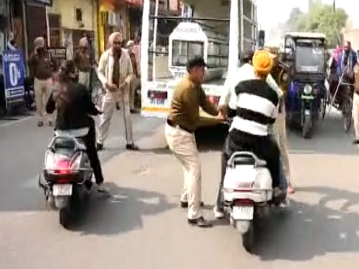 वाहन चालकों को रोकते पुलिस कर्मचारी।