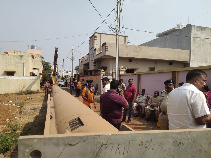 जमीन पर पड़ा टॉवर और उसका विरोध करते मोहल्ले के लोग