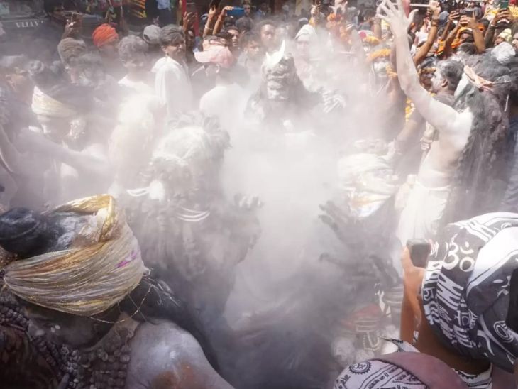 गले में रूद्राक्ष और नरमुंड माला पहने शिवभक्त चिताओं की राख से होली खेलते हुए।