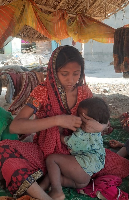 गुड्डू की पत्नी बच्चे को दूध पिला रही हैं।