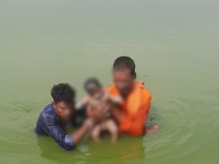 नदी से निकालकर बच्चे को बाहर लाते हुए लोग, इस मंजर को देखकर अपनी आंसू रोक नहीं पाए। - Dainik Bhaskar