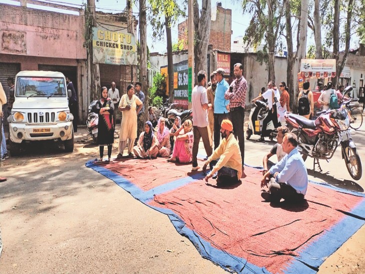 शराब ठेके के आगे धरना प्रदर्शन करते हुए गांव वासी - Dainik Bhaskar