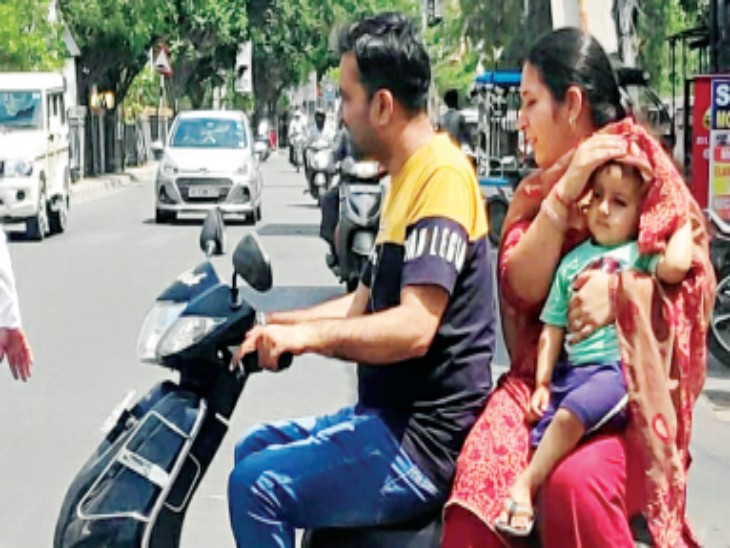 रोहतक में बच्चे को धूप
से बचाती एक महिला। - Dainik Bhaskar