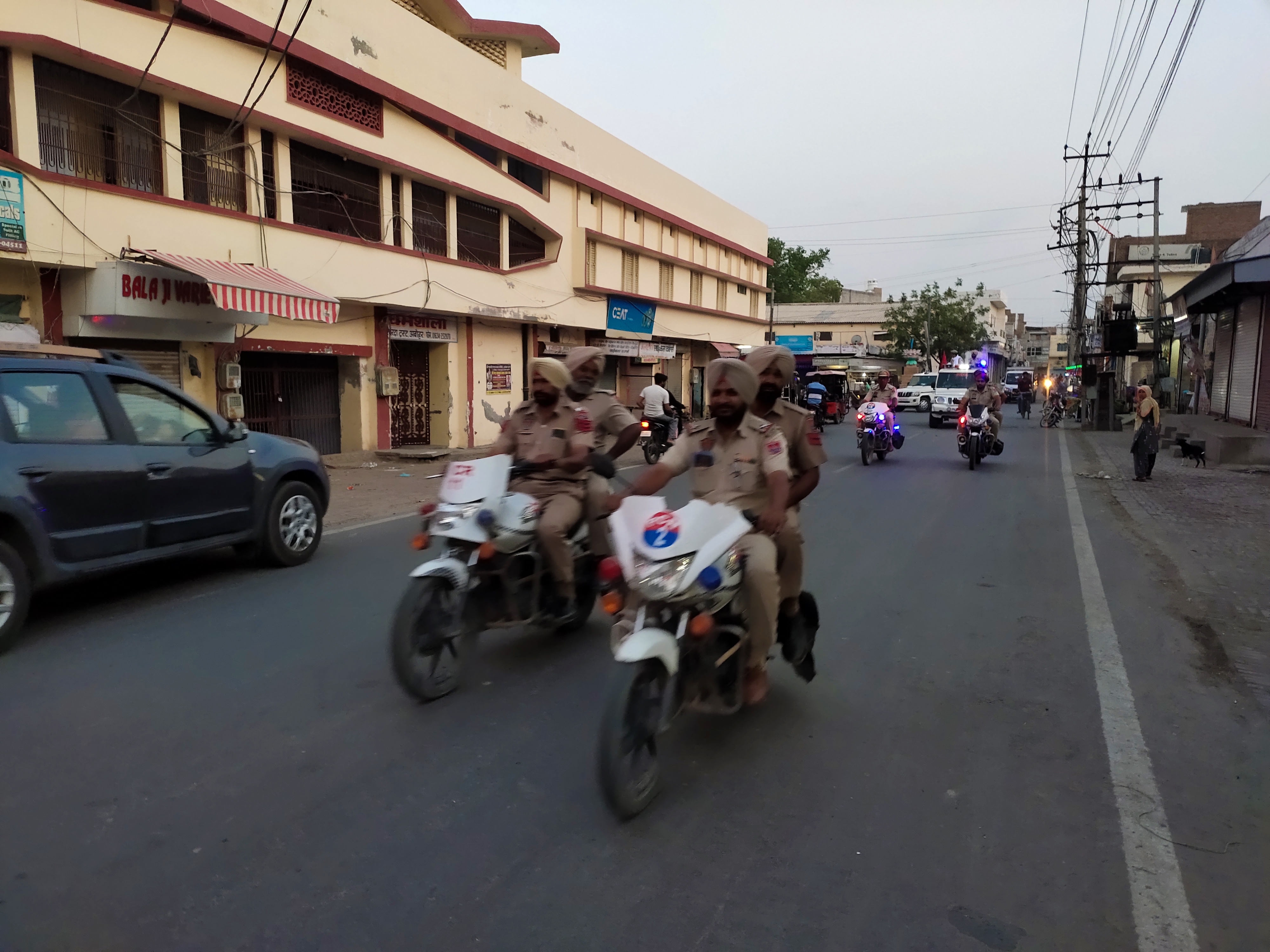 अबोहर में फ्लैग मार्च निकालते पुलिस कर्मी। - Dainik Bhaskar