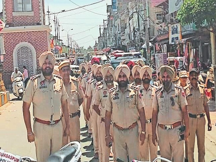 शहर में फ्लैग मार्च निकालते पुलिस मुलाजिम। - Dainik Bhaskar