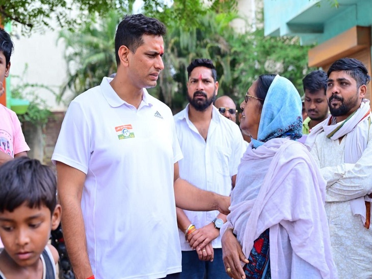 विधायक महिला से विकास के बारे में चर्चा करते हुए।