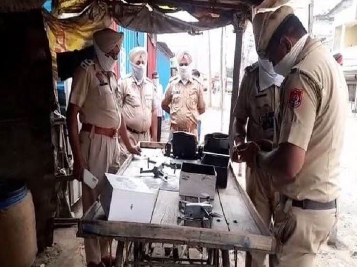 इलाके का जायजा लेने के लिए ड्रोन उड़ाने की तैयारी करते पुलिस कर्मचारी।